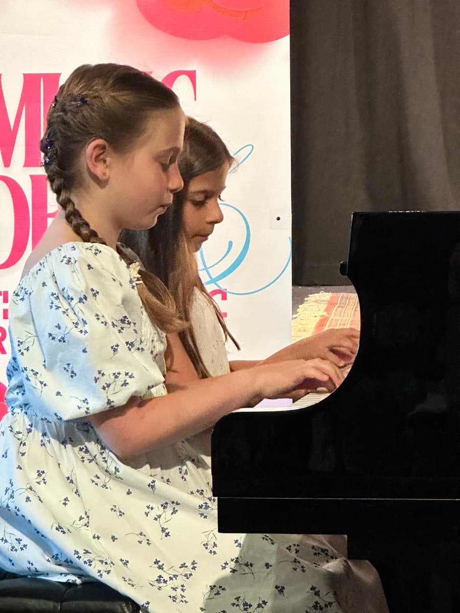 Two students performing a duet, four hands at one piano