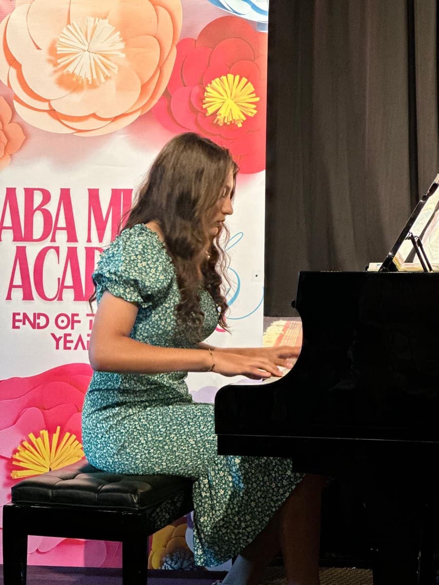 A teen student performing advanced repertoire at the grand piano