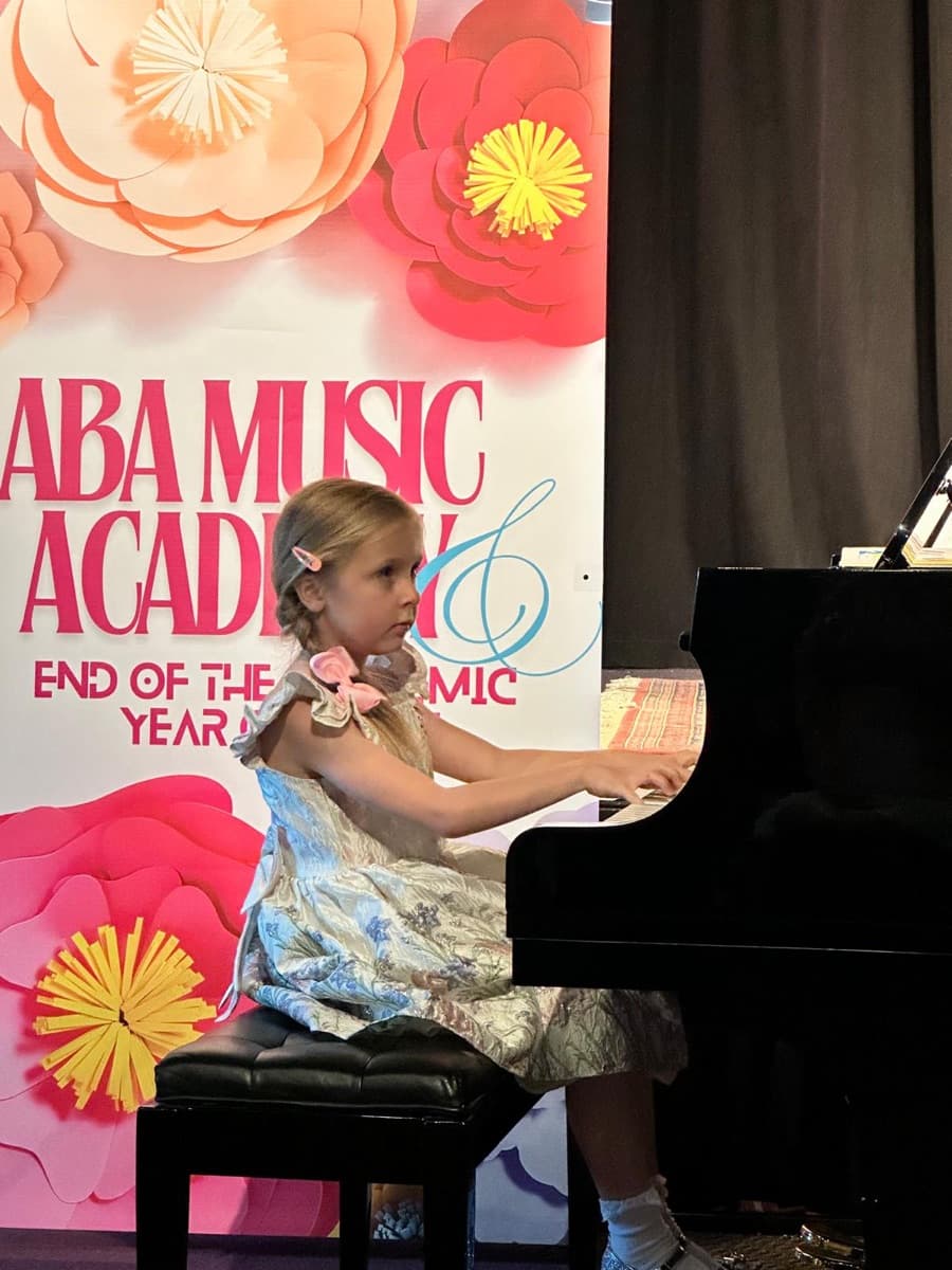 A young beginner performing at ABA Music Academy's 2026 end-of-year concert